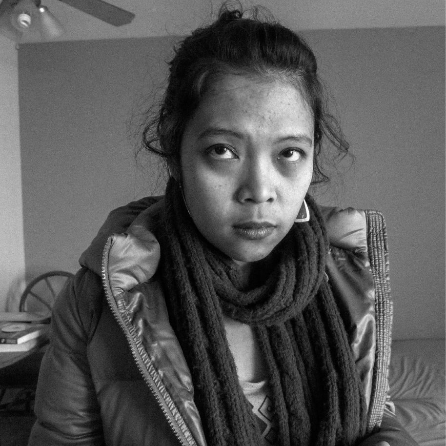 Portrait of a woman in a scarf and jacket, photographed indoors, from REINKARNASI