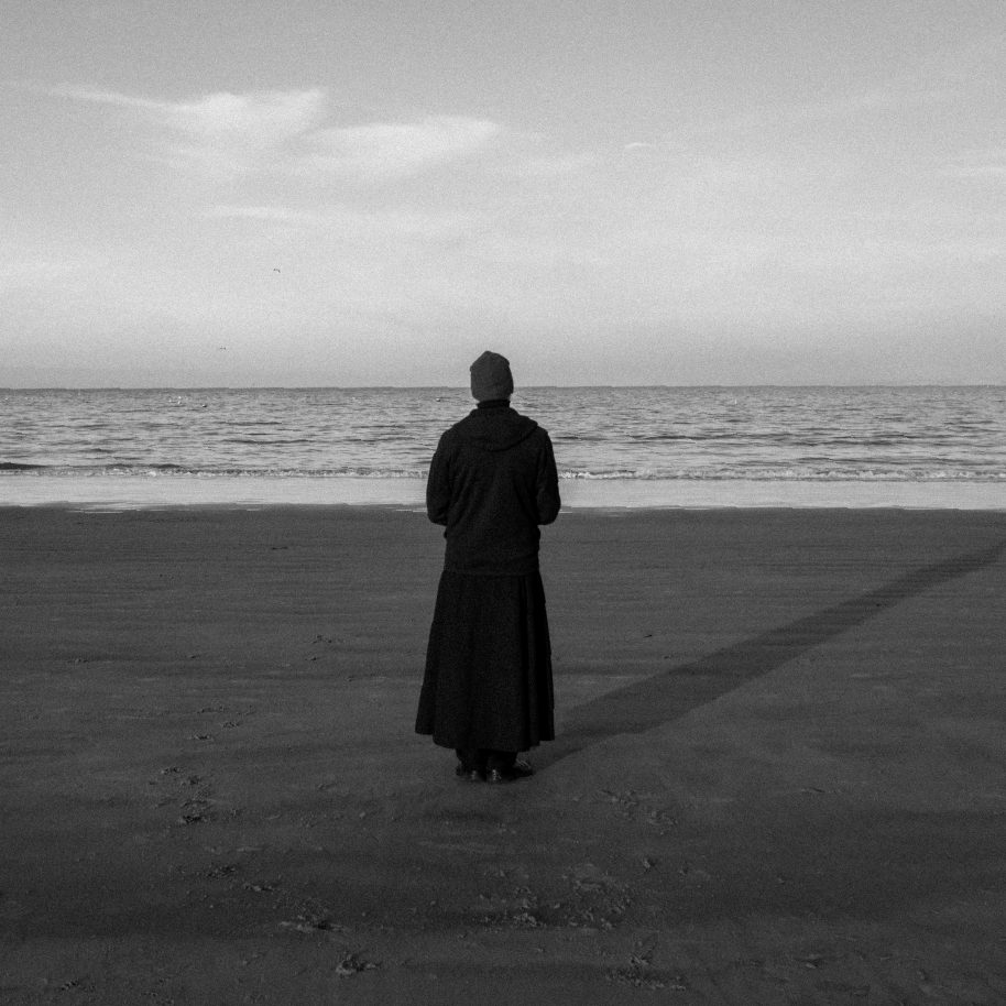 Back cover of REINKARNASI — a figure standing alone at the shoreline
