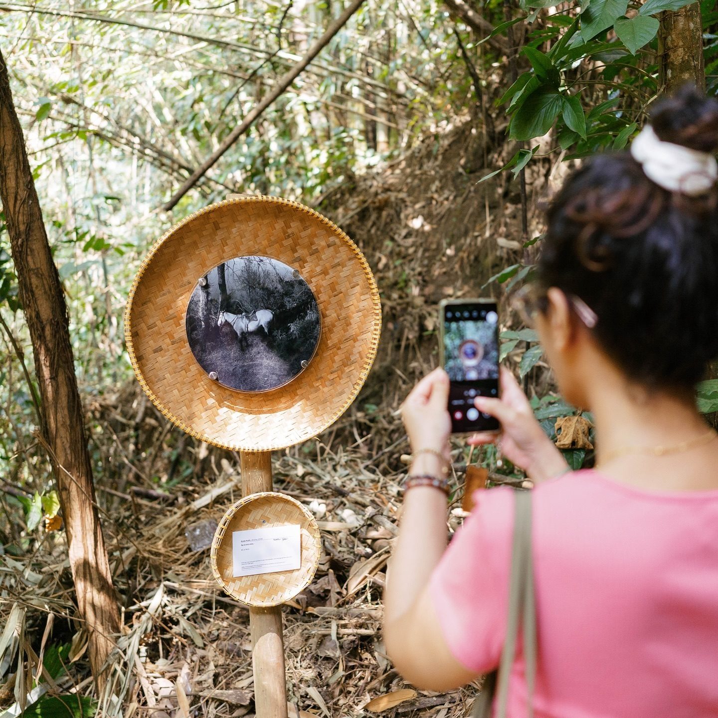 A visitor photographing a print at Omah Lor Project, Pakem
