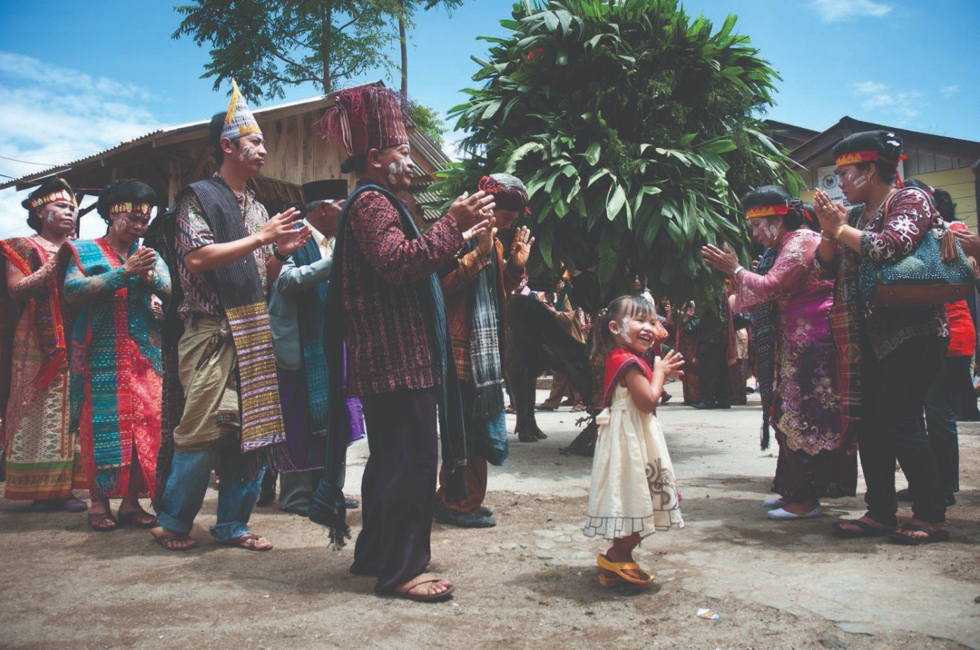 Elders in ulos clapping as a small girl dances, Mangalahat Horbo ceremony, Samosir