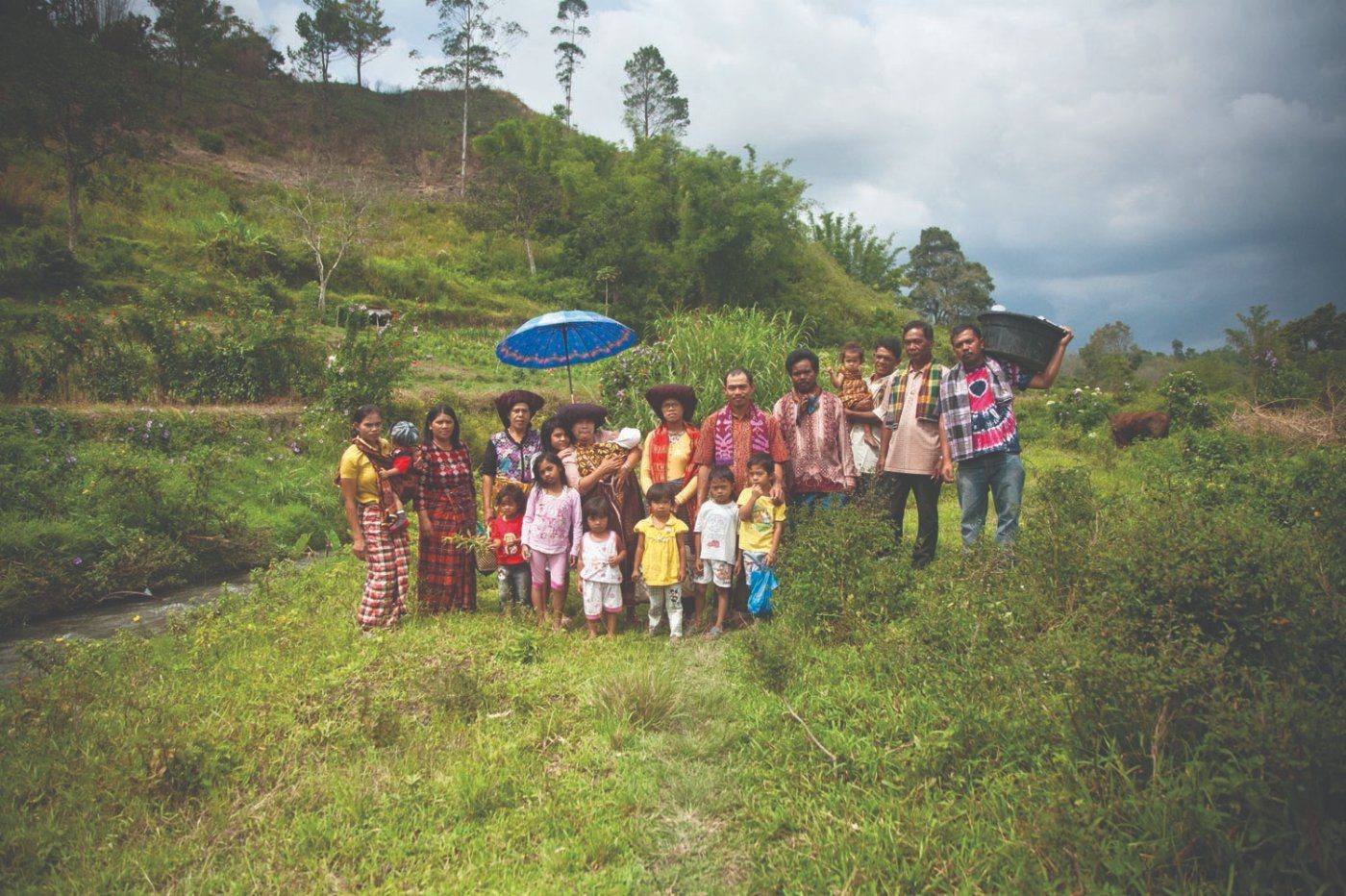 A family gathered by the river for the Sirembah Ku Lau ritual, Tanah Karo
