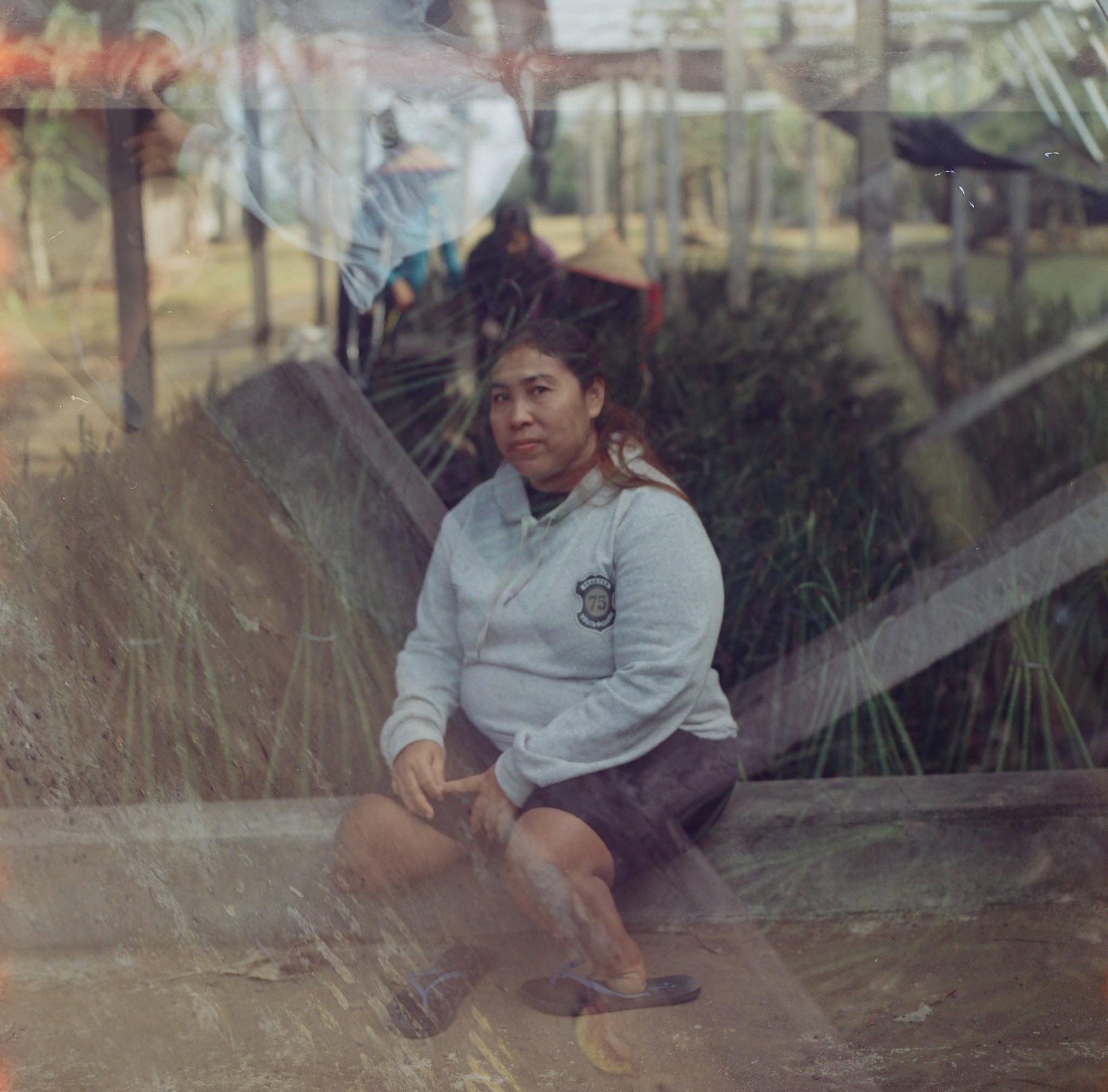 Double-exposed portrait of a woman seated in the mangrove nursery