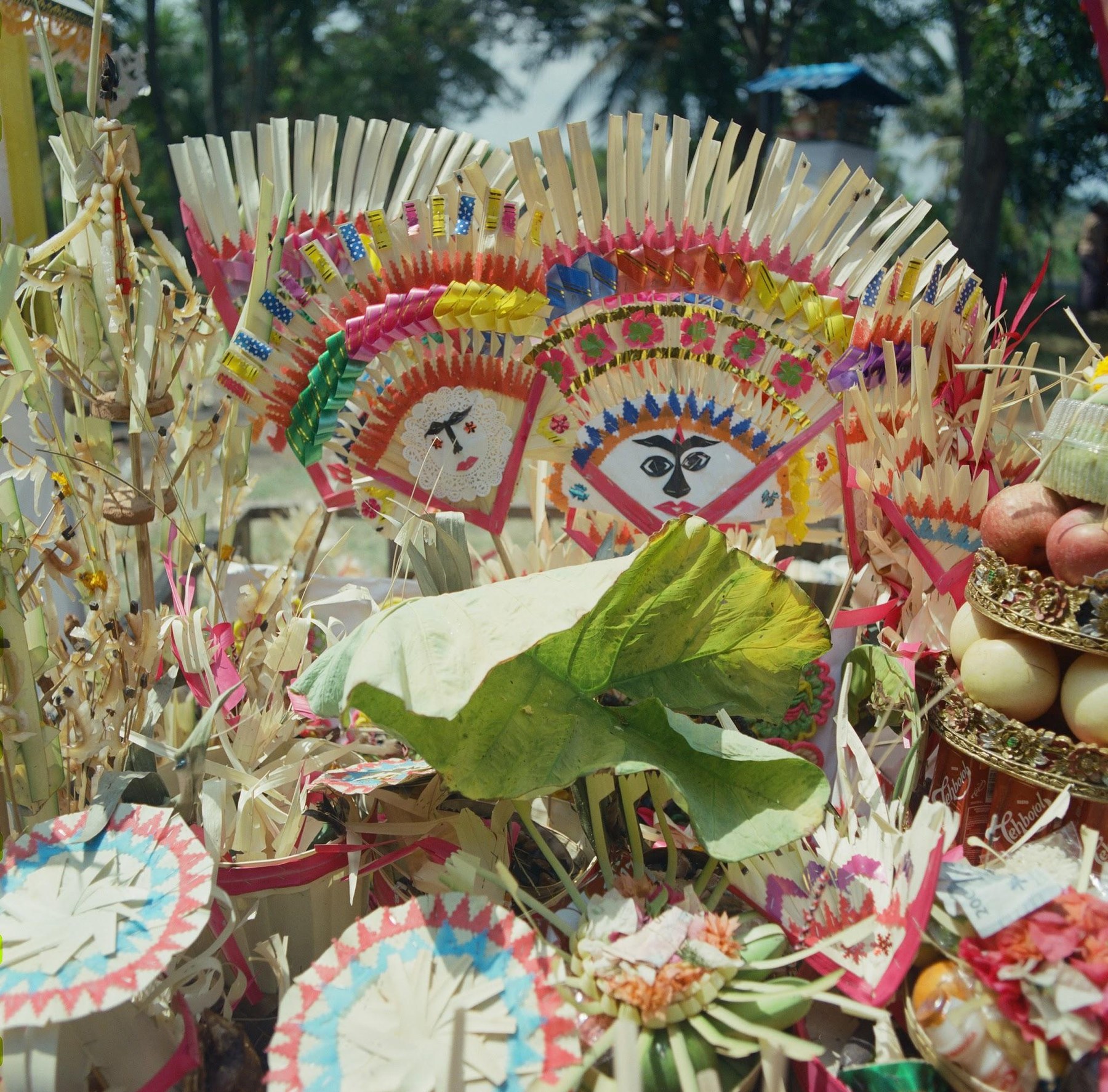 Colourful Balinese offerings with painted faces, made for a Ngaben ceremony